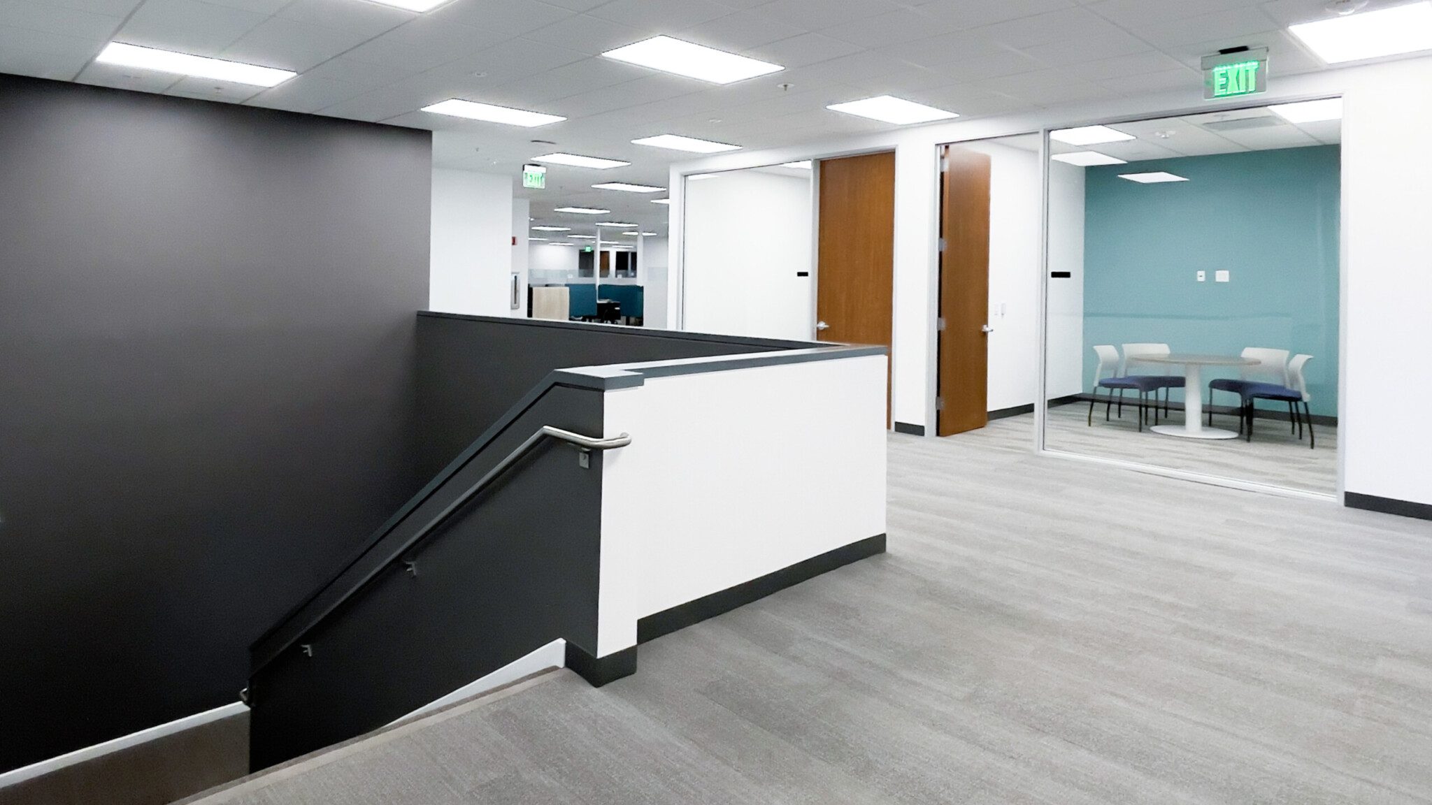 Staircase lobby with conference rooms and cubicles visible 